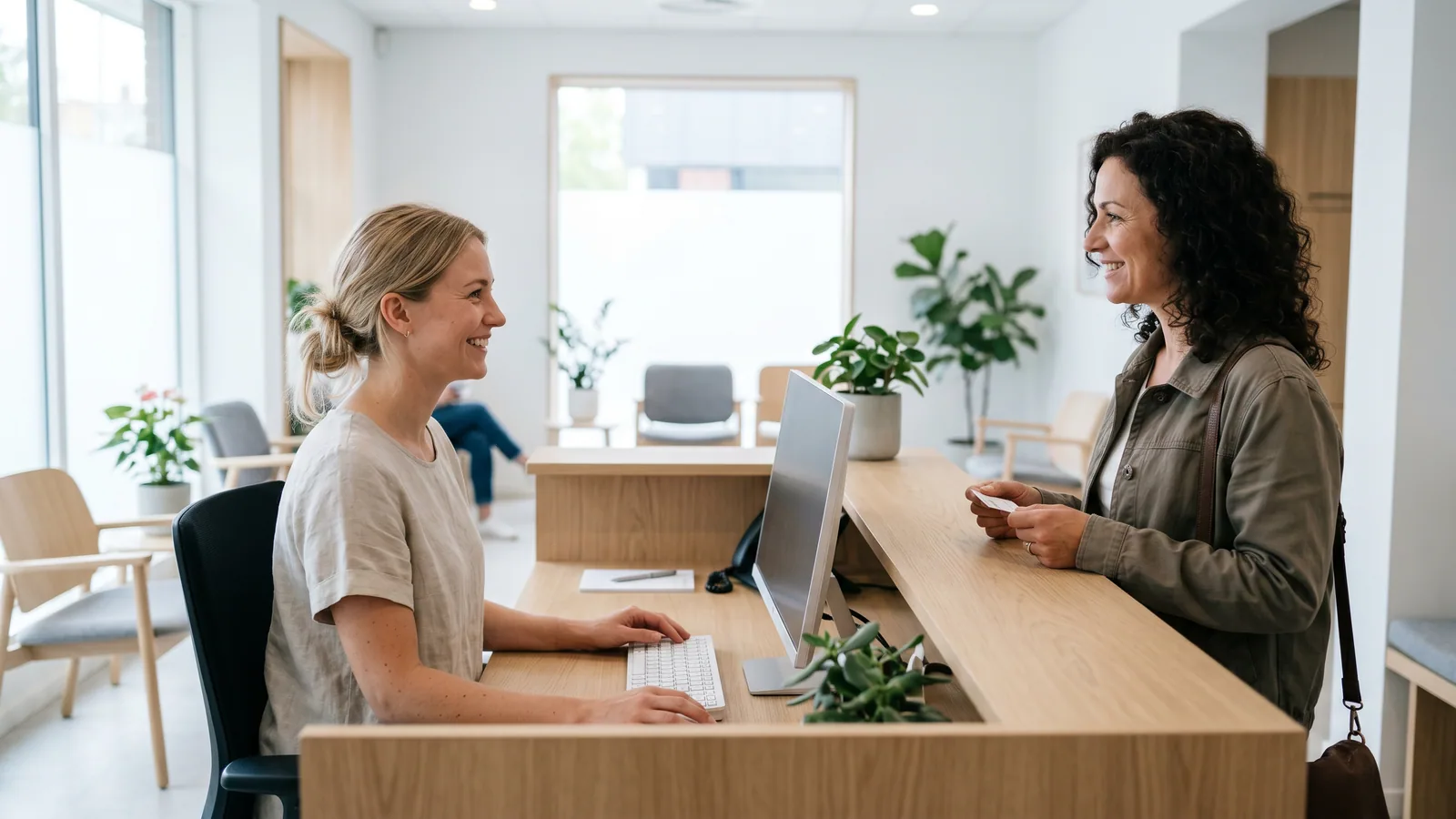 Receptionist tager imod en patient i en lys øjenklinik