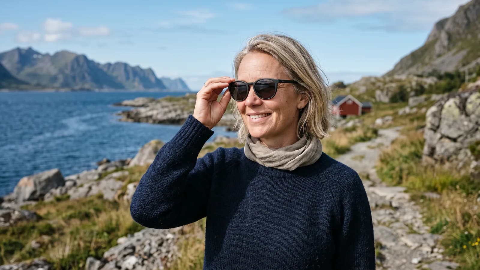 En kvinde i 40'erne tager solbriller med UV-filter på en solrig dag ved kysten, beskyttelse mod UV-stråler, der kan give pinguecula.